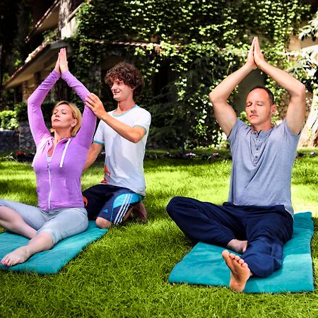 מלון טקירובה Marti Myra מראה חיצוני תמונה A yoga teacher assists students with their practice.